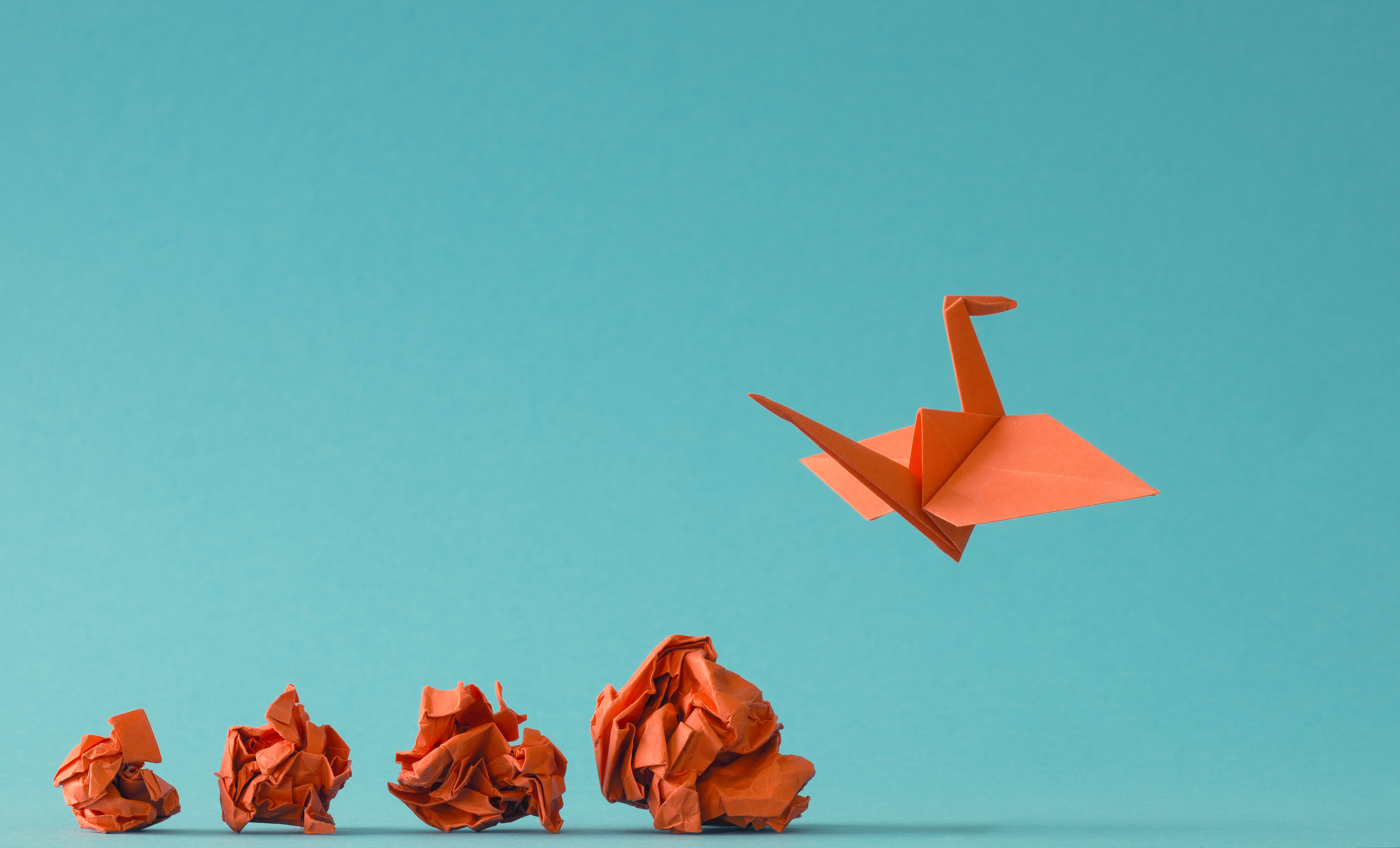 Balls of paper transforming into an origami crane