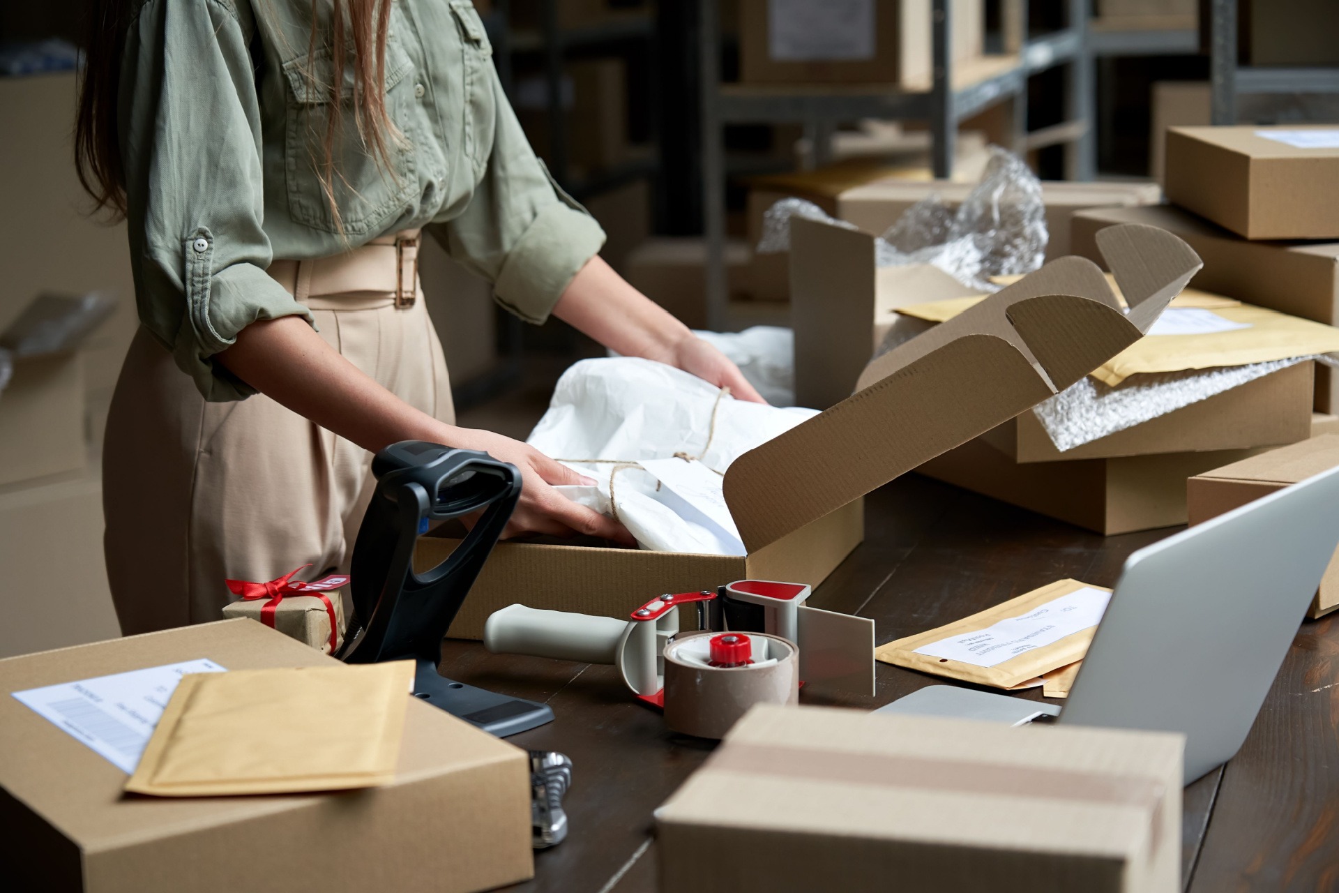 Fashionable woman packing clothes for an online order