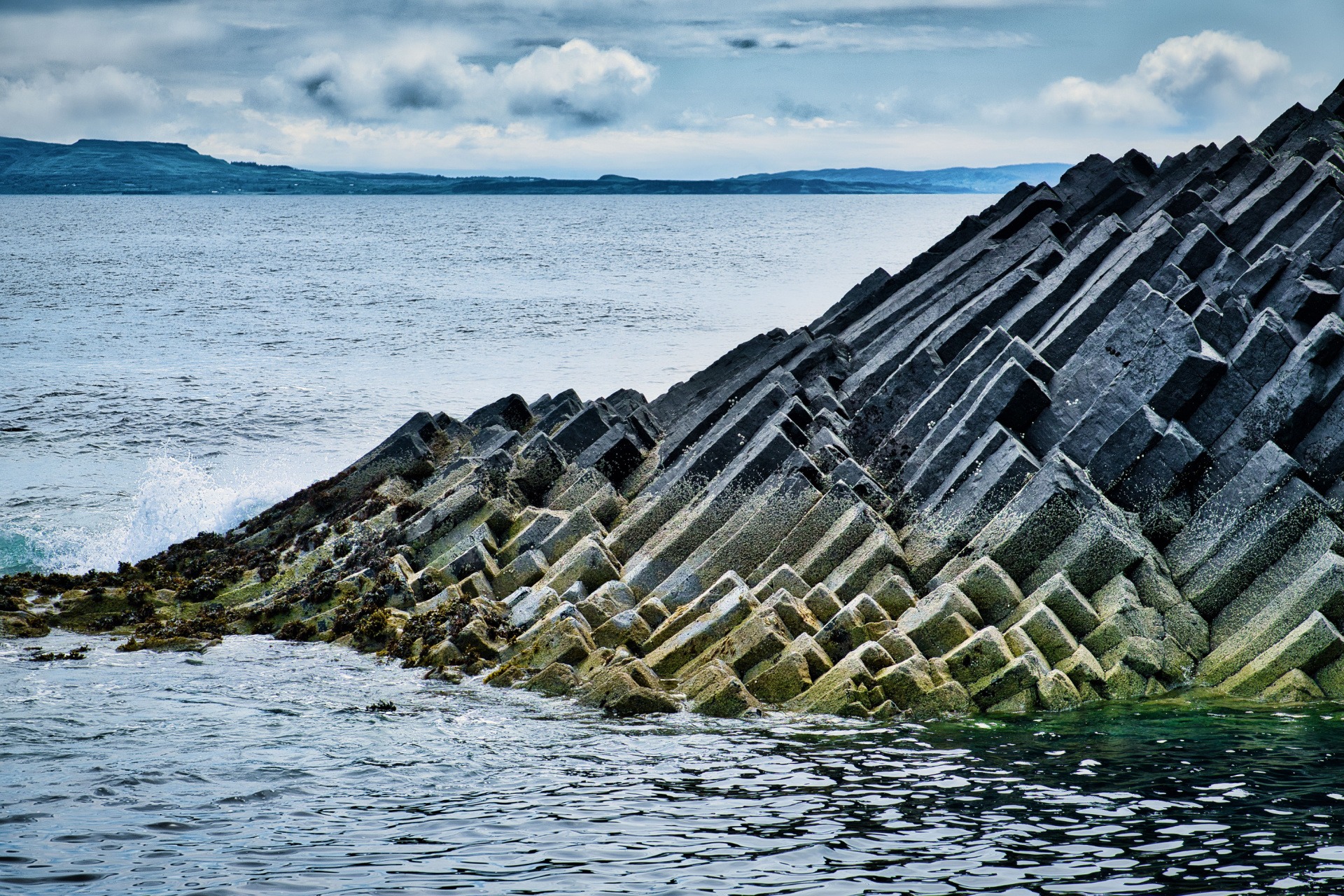 Geometric rock formations jutting upward from the sea