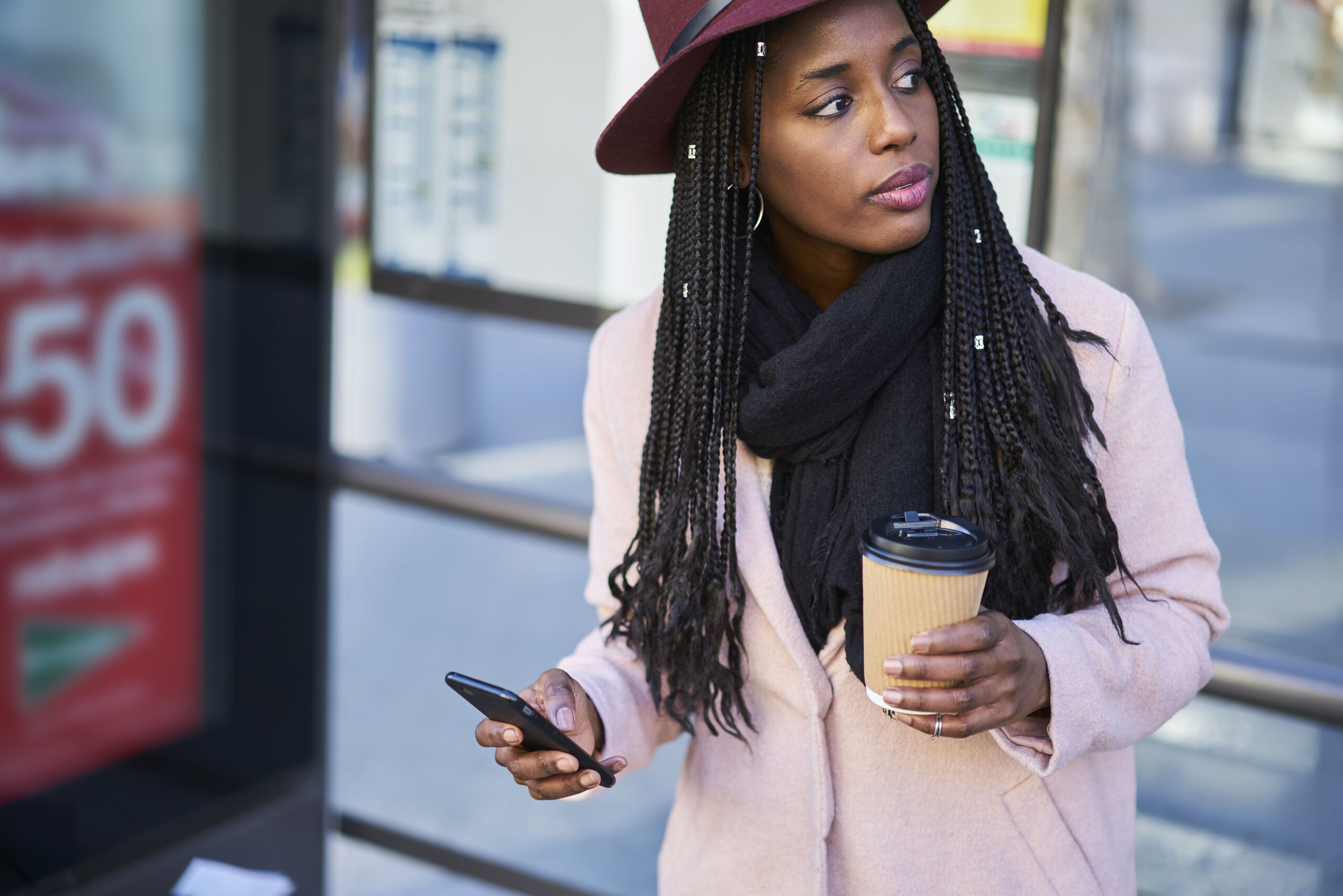 Woman checking her phone at a bus stop