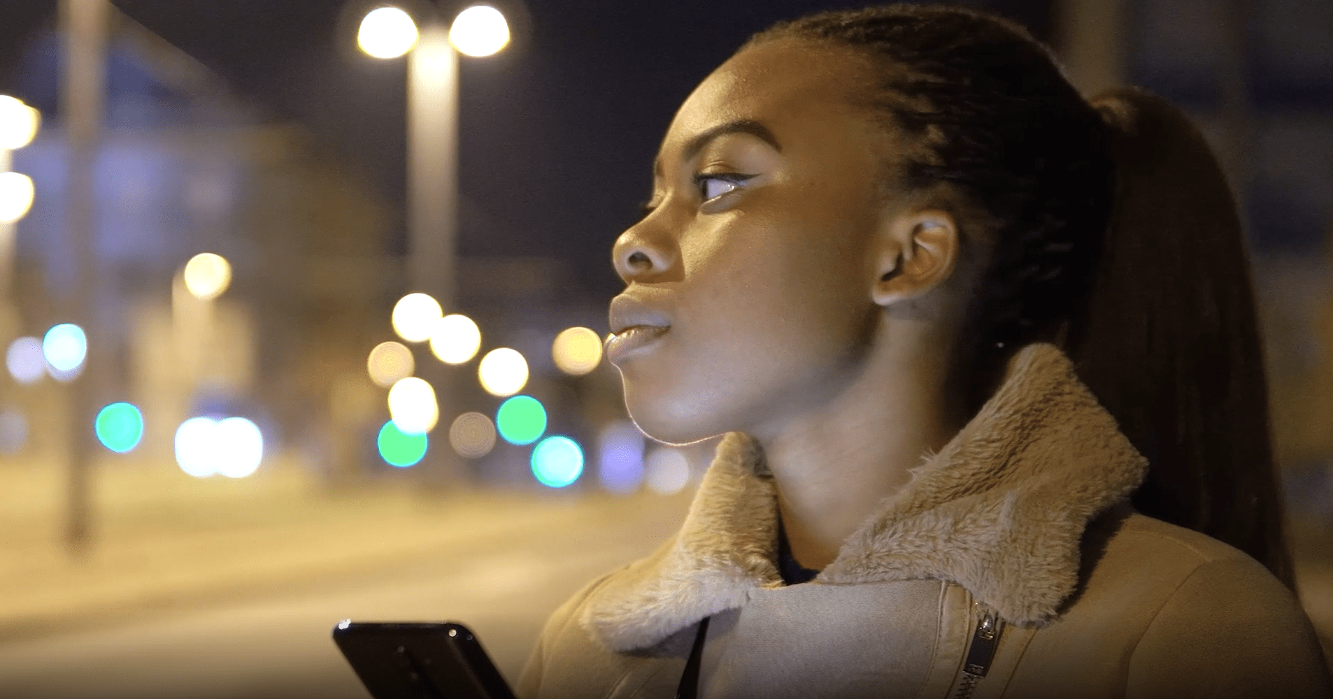 woman holding her phone and looking to her right