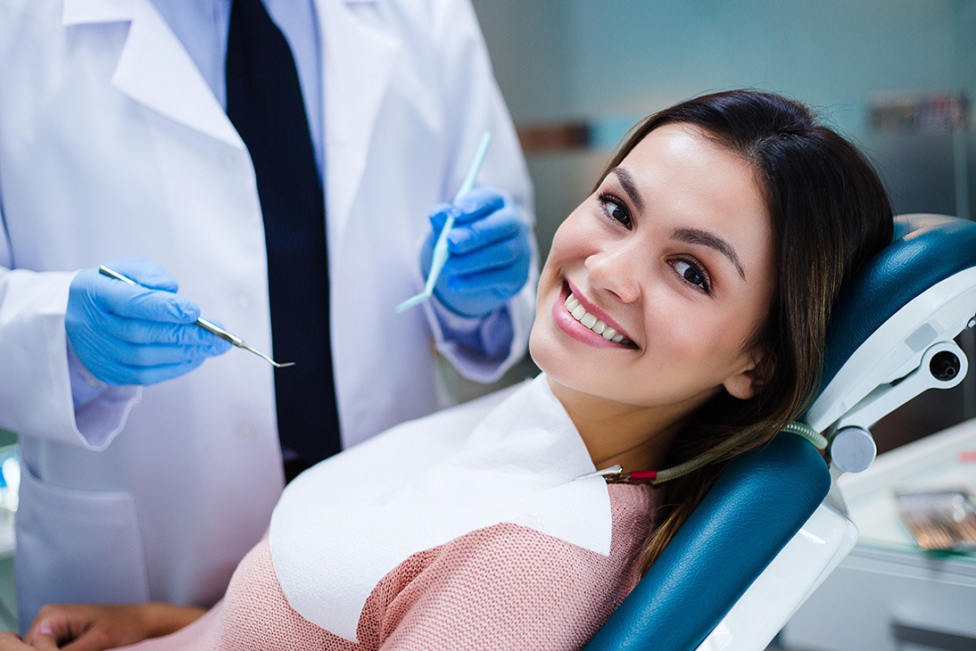 Her amazing smile! Beautiful young woman looking at camera with smile in dentist’s office