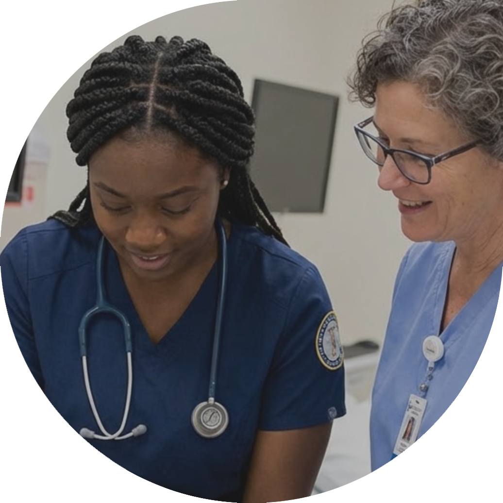 A nursing student works with her teacher in a classroom